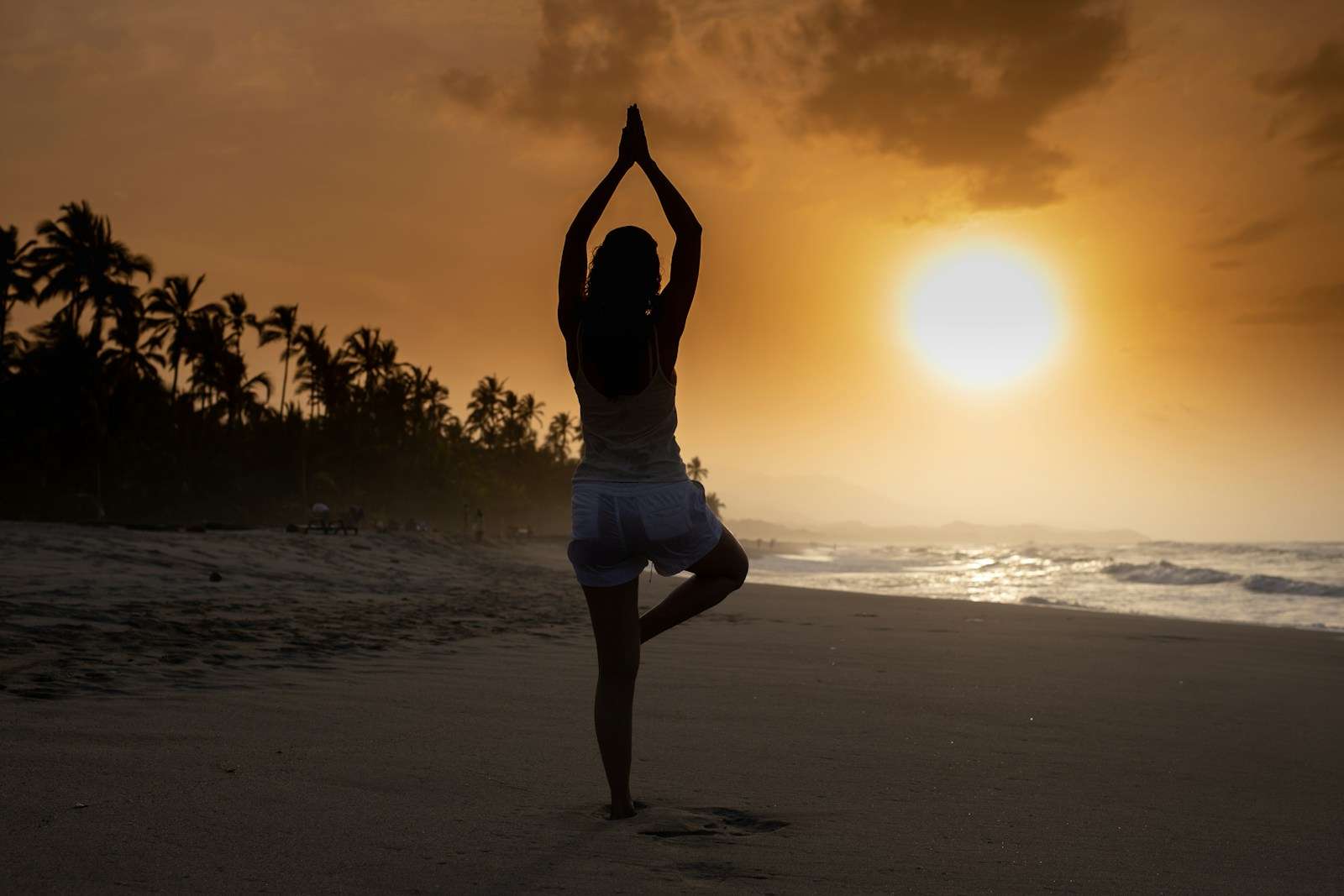 Heart healthy exercise tips woman in white tank top and white shorts standing on beach during sunset