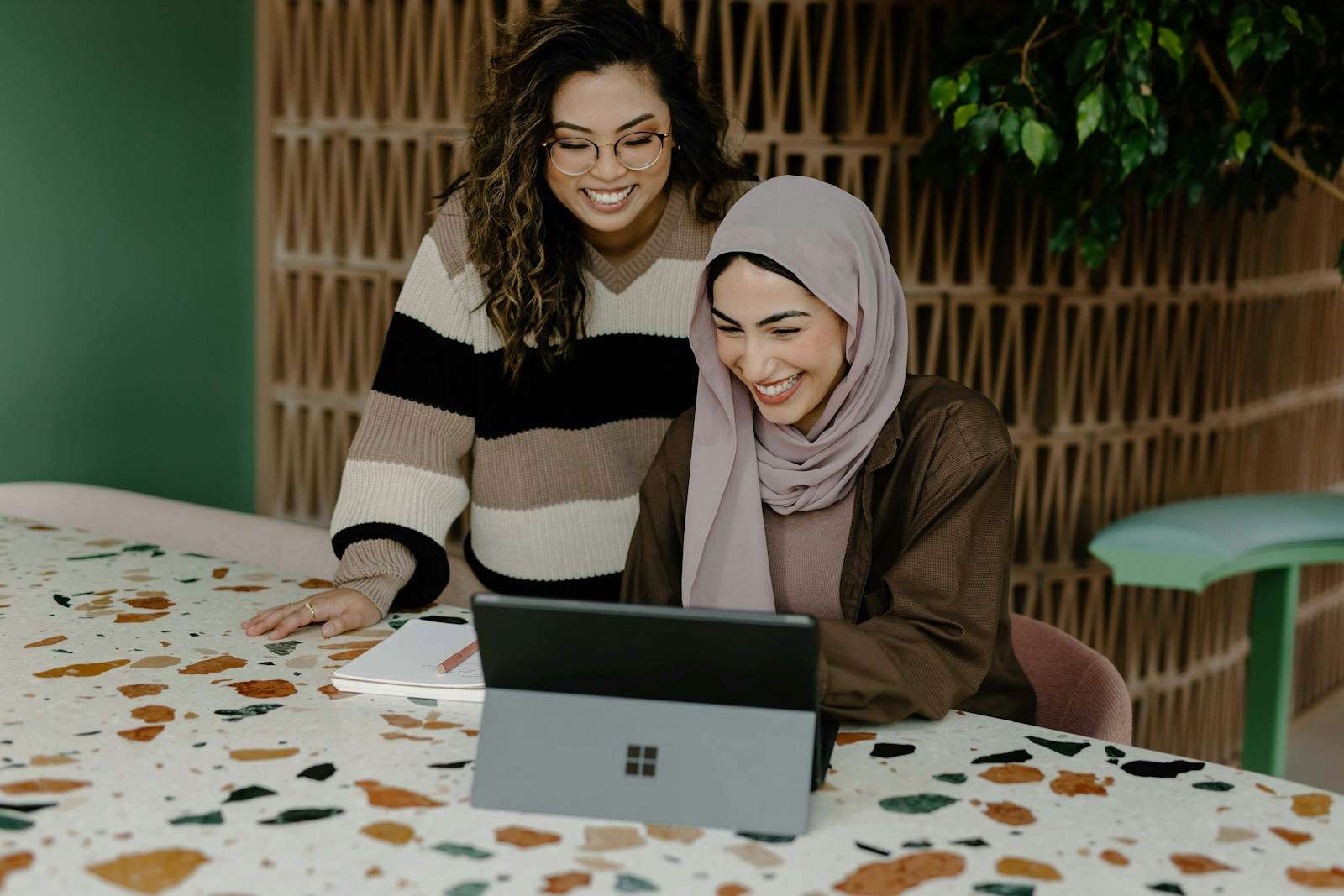 Franchising Two women sitting at a table with a laptop