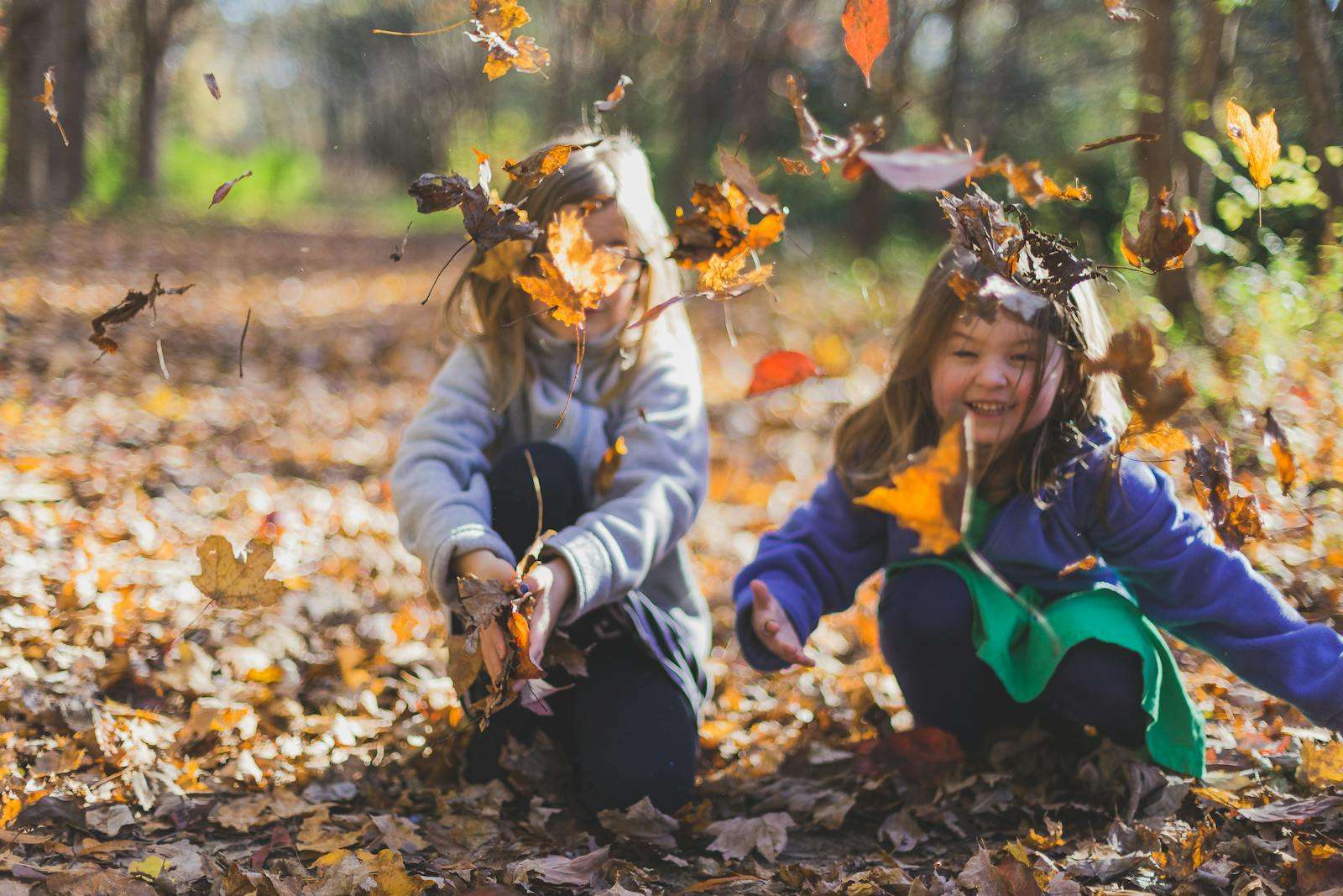 Caregivers and children Photo of Children Playing With Dry Leaves