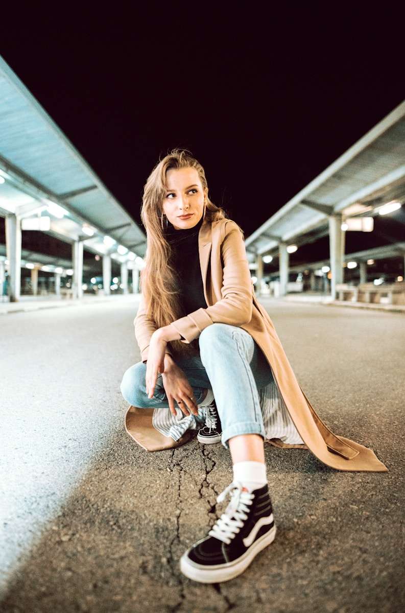 Fabrics A woman sitting on a skateboard in a parking lot