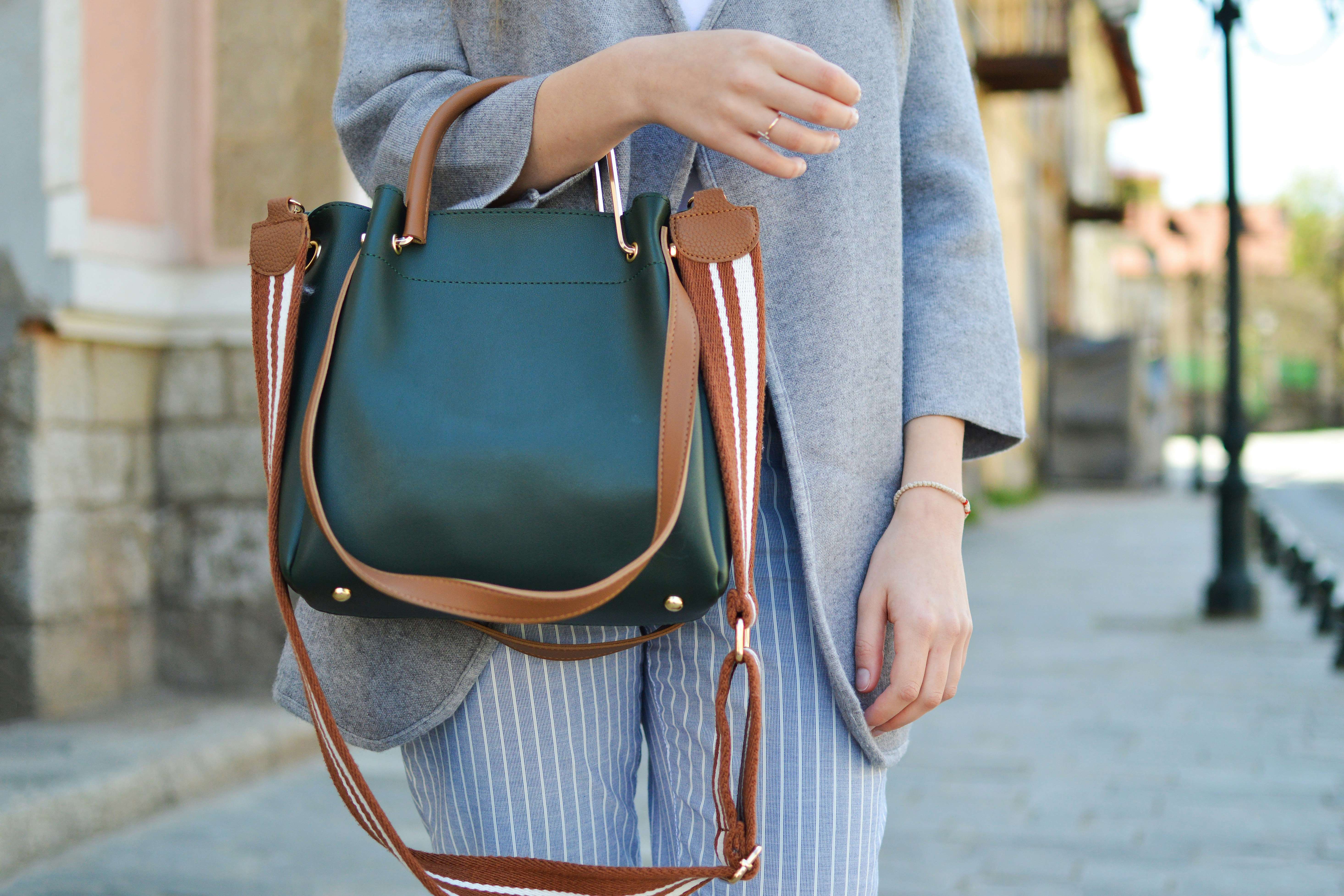 7 best handbags for busy moms - woman carrying green and brown handbag