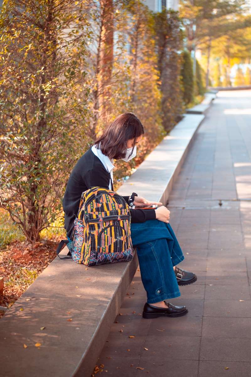 Managing stress woman in black suit sitting on sidewalk during daytime
