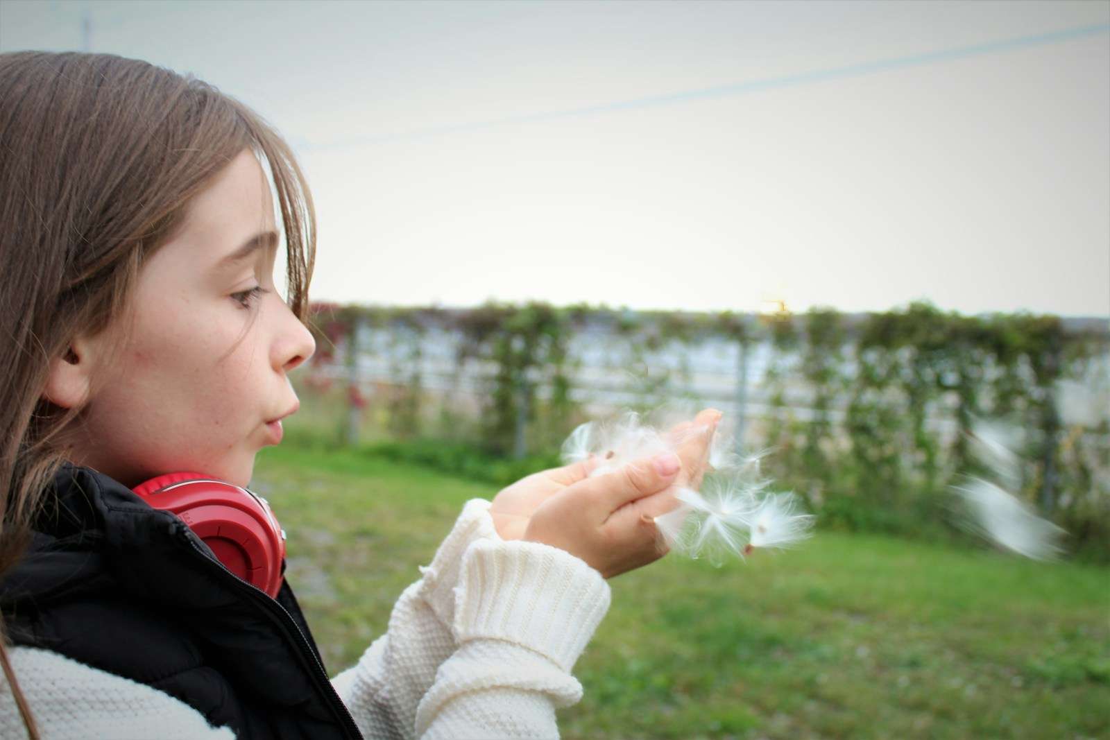stay true to yourself girl in white knit scarf holding white dandelion flower during daytime