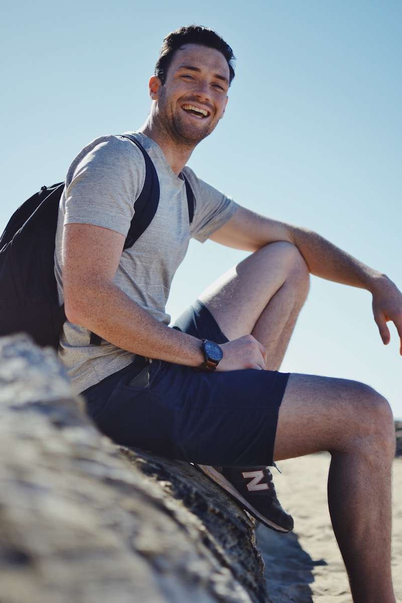 Wellness After a Vasectomy: What to Expect and How to Adjust A smiling man sitting on gray rock at daytime