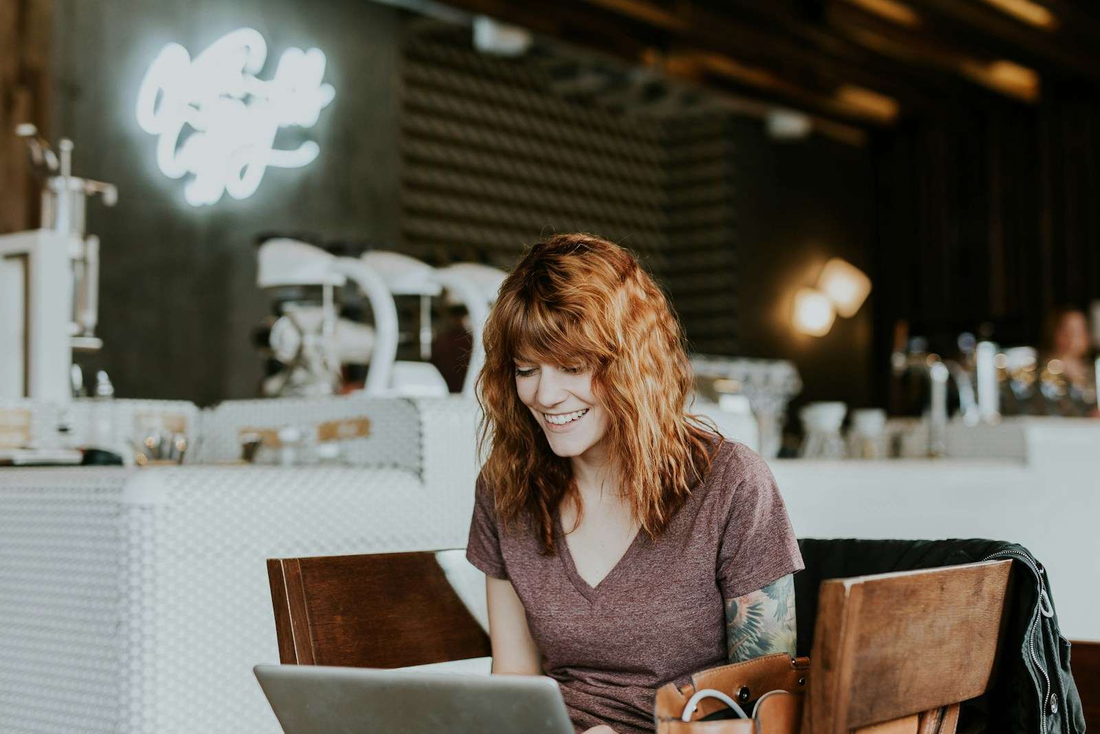 payroll software woman sitting on brown wooden chair while using silver laptop computer in room