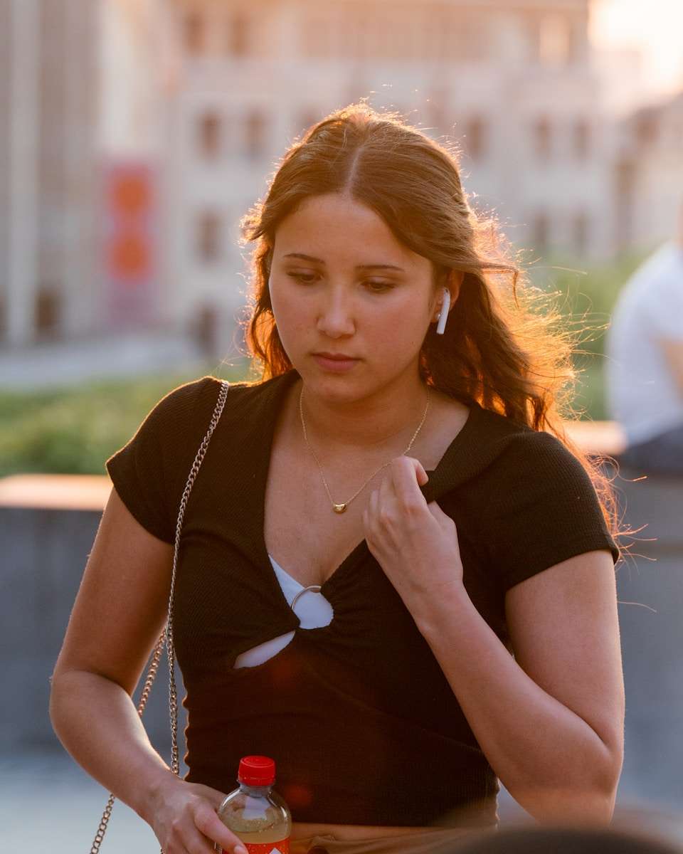 Everyday accessories A woman holding a hot dog and a bottle of coke