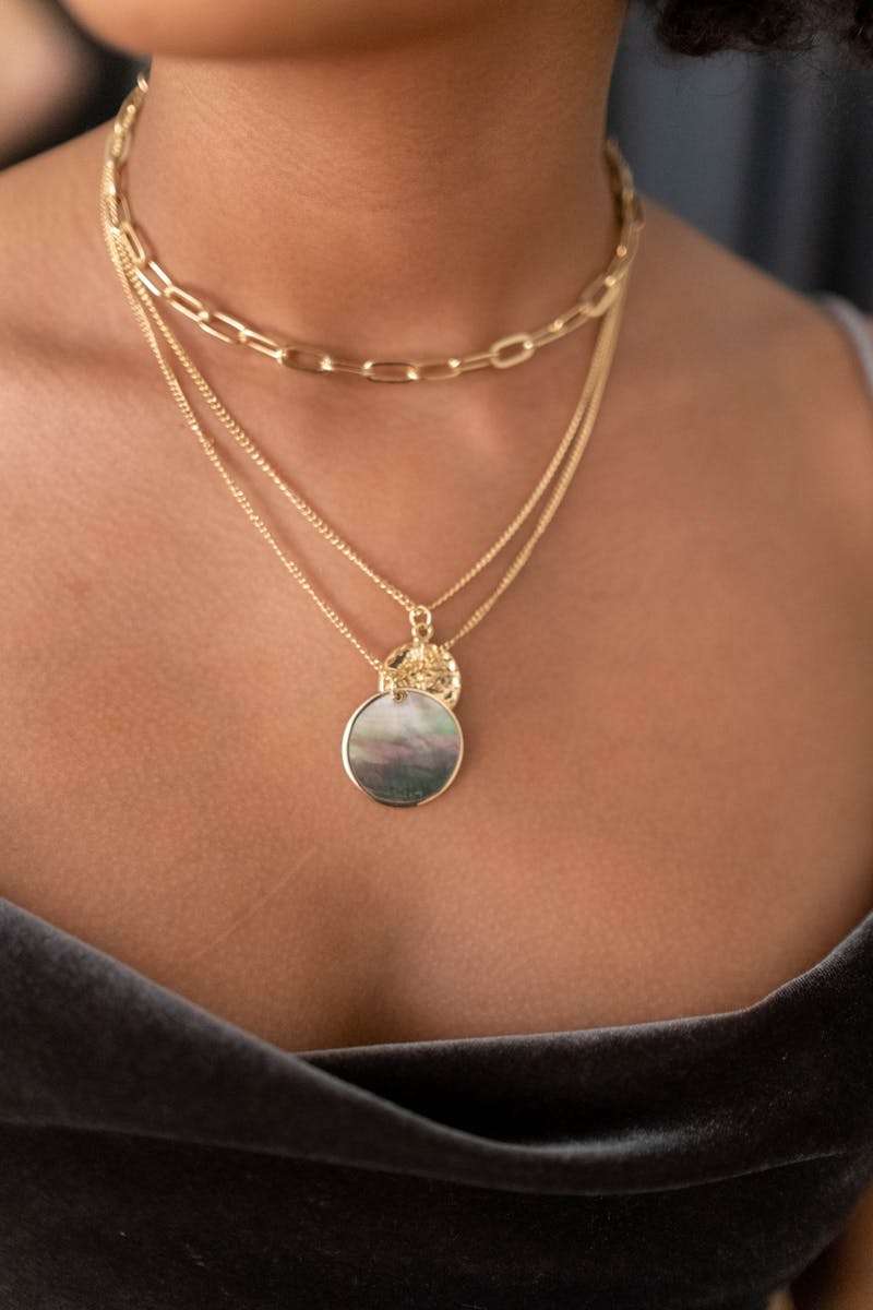 Jewelry Close-up of a layered gold necklace on skin, showcasing a chic and elegant design.