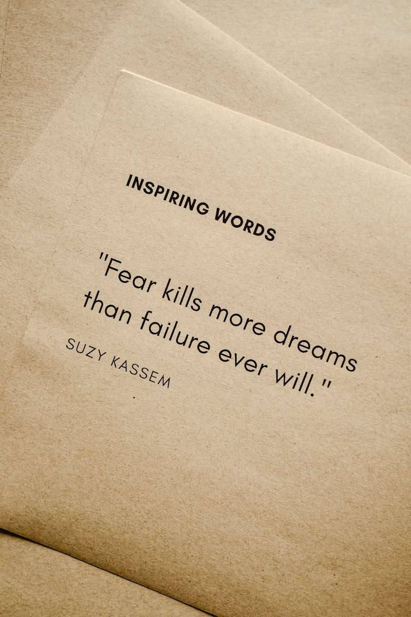 Taking action to live the life of your dreams Motivational quote 'Fear kills more dreams than failure ever will.' by Suzy Kassem on paper texture.