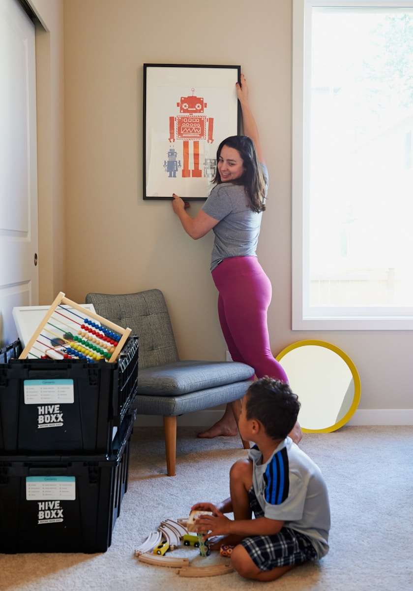 10 Smart (and Sanity-Saving) Tips for Setting Up Your New Home woman in gray shirt and pink pants sitting on gray chair