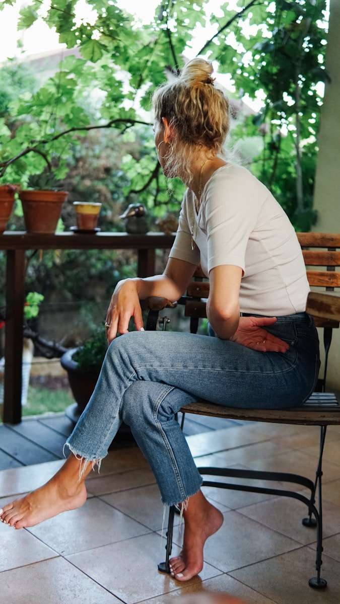 How to Find the Way Forward When Life Feels Too Heavy woman in white t-shirt and blue denim jeans sitting on brown wooden bench during daytime