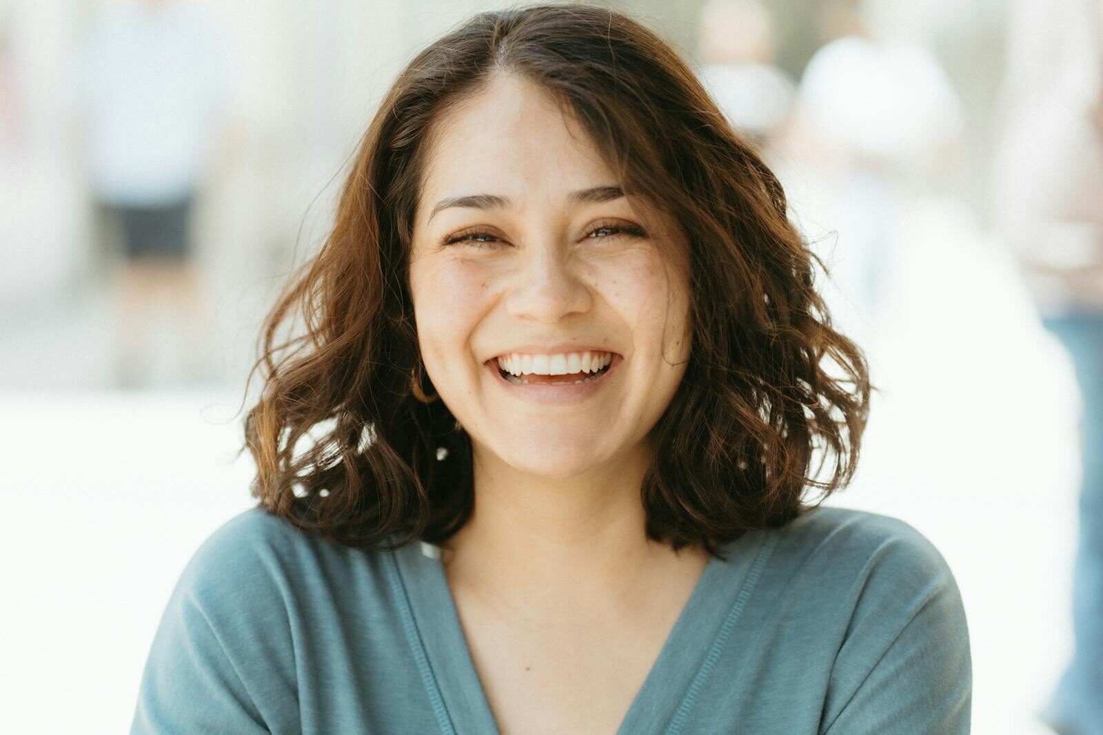Dental Implants: A Comprehensive Guide to Modern Tooth Replacement Options A joyful woman smiling broadly against a sunlit outdoors background. Warm and inviting photo.