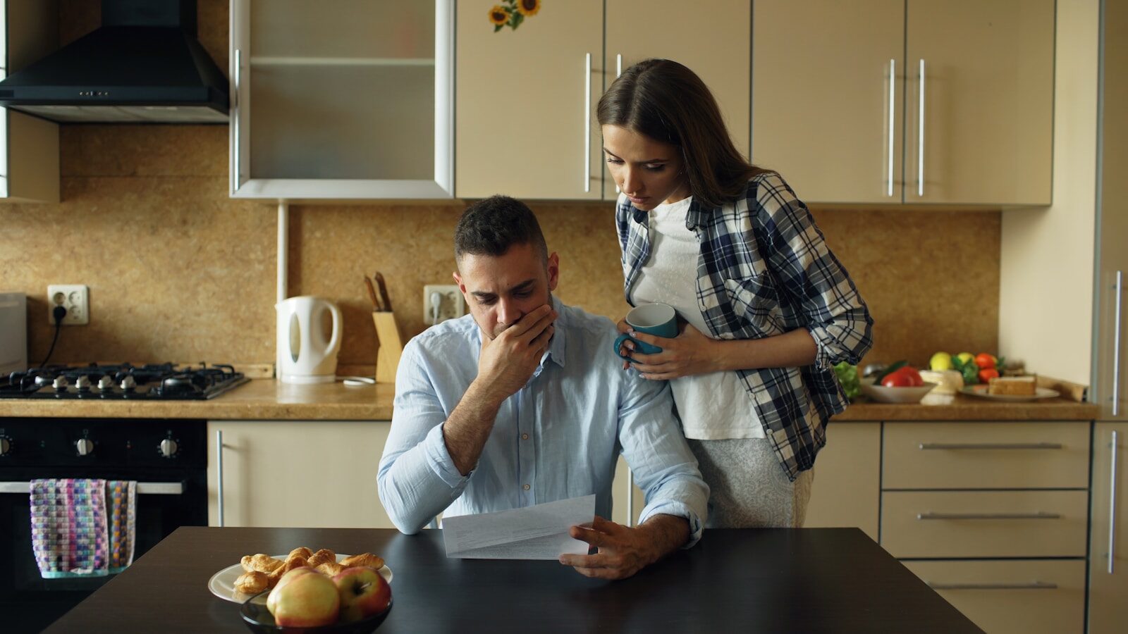 Financial Planning for the Modern Professional: Strategies for Effective Wealth Management Couple looking stressed over bills at kitchen table.