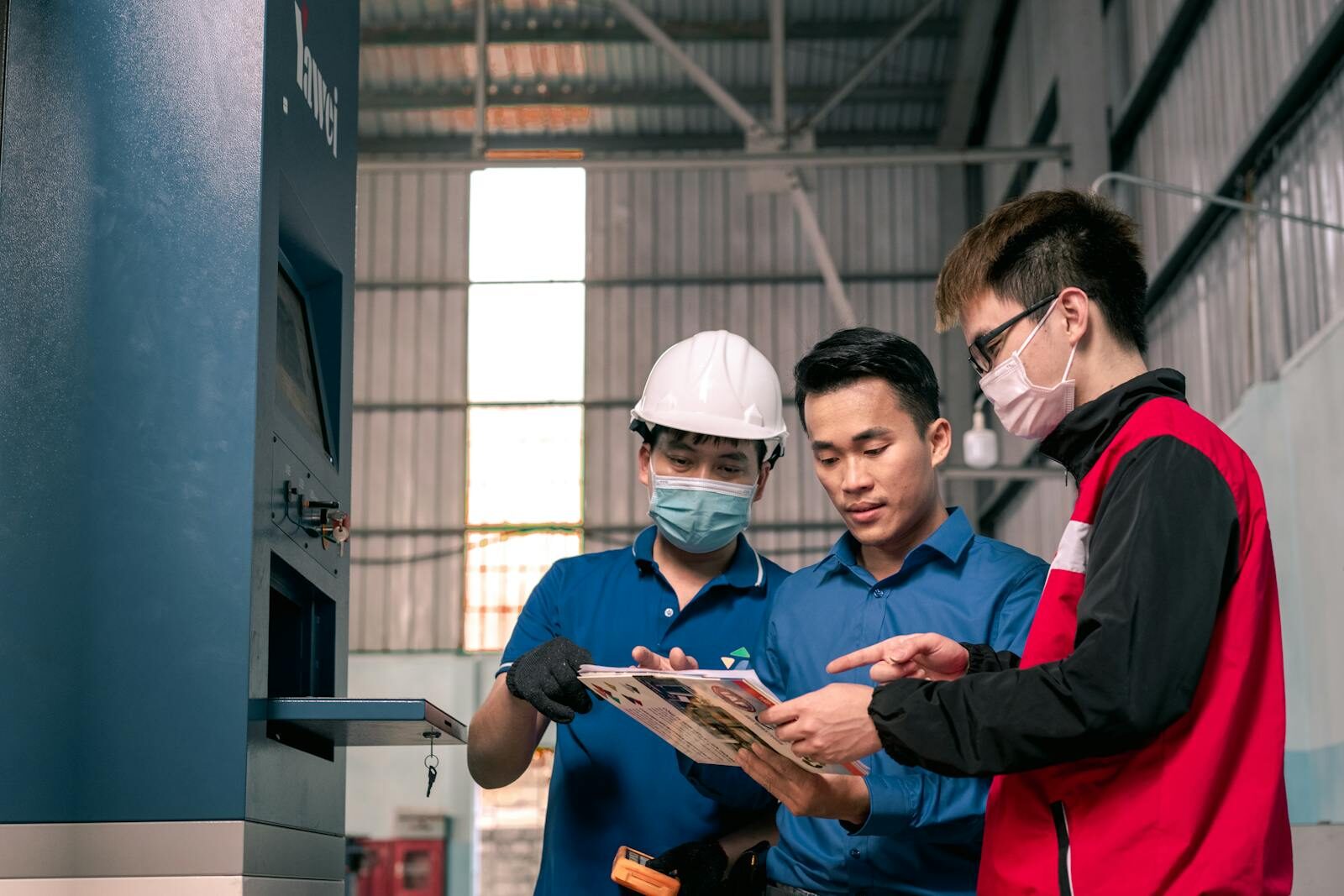 explore the innovative practices shaping the future of safety and efficiency in chemical plants and refineries, as well as highlight the advances that are setting new standards worldwide. Workers in a warehouse reviewing blueprints, emphasizing teamwork and safety.