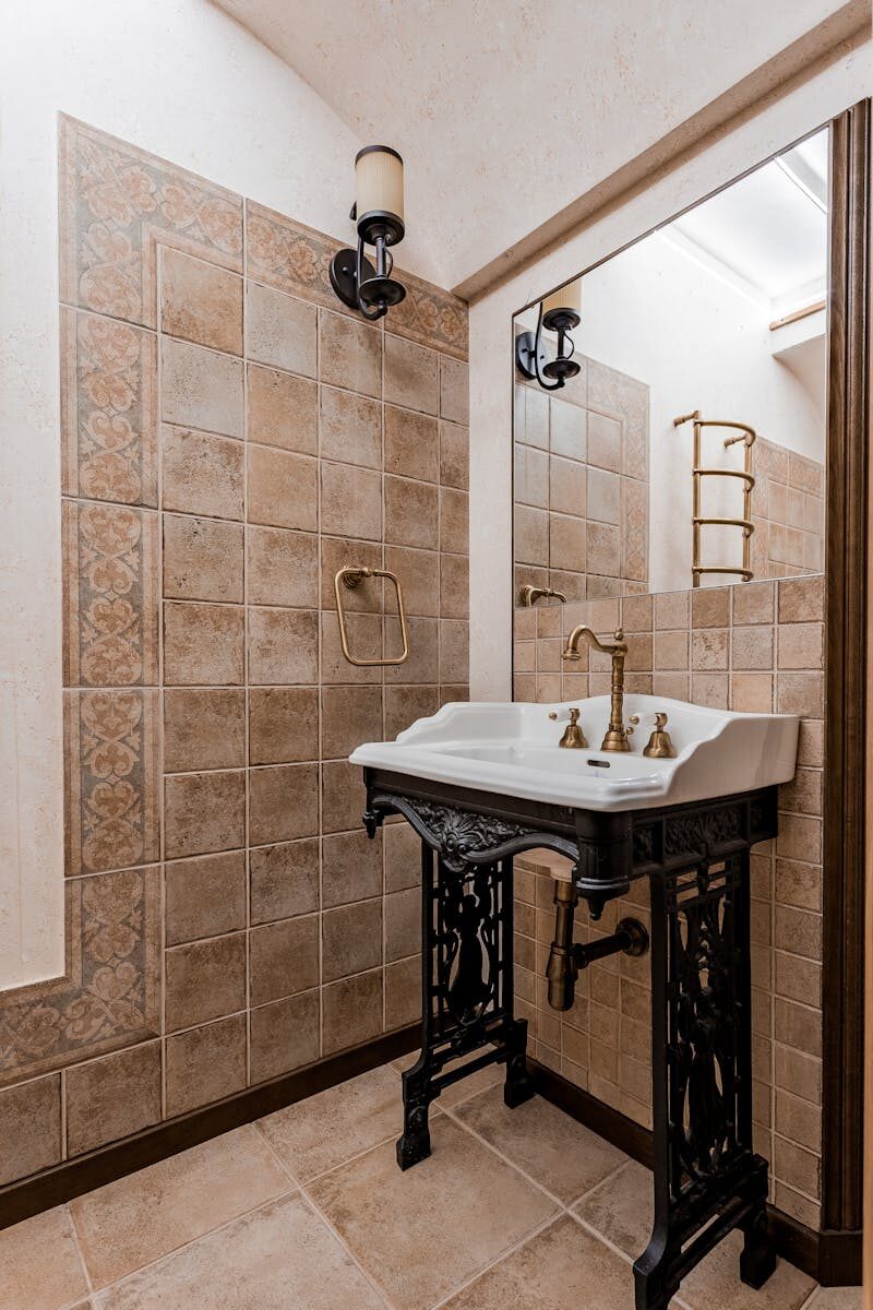 How to Tile a Bathroom Wall Yourself Without Ruining It Stylish vintage-style bathroom with ornate sink, tiled walls, and classic fixtures.