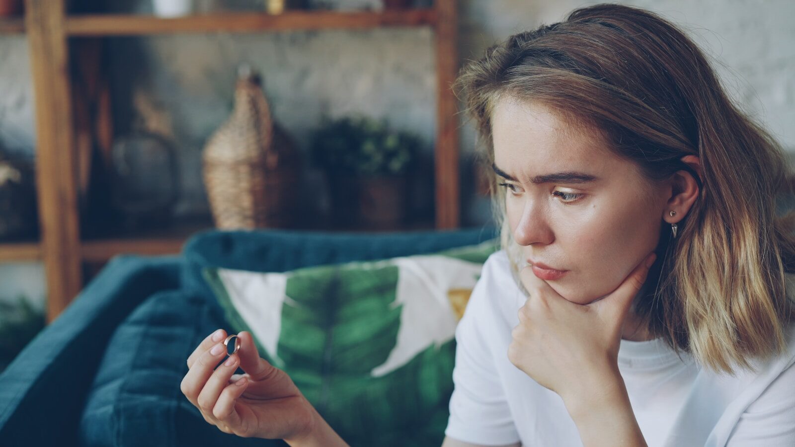 When a Marriage Ends But Life Doesn't: What I Learned About Moving Forward Young woman looking at a small object in her hand.