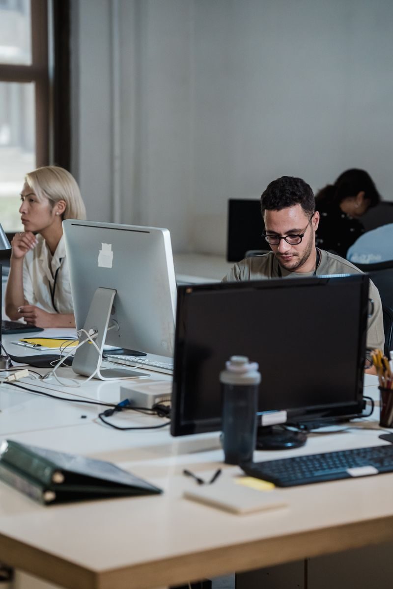 Norbert Vergez: Why Cybersecurity Is a Core Requirement in Modern Project Management Modern office space with diverse team working diligently at desks.