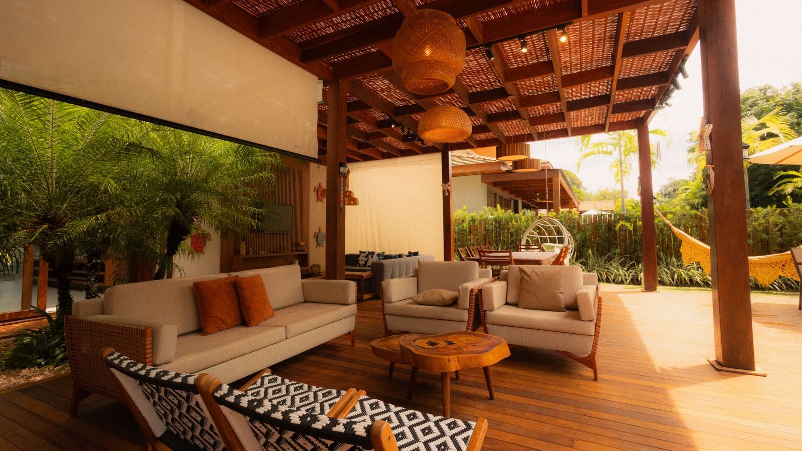The Benefits of Outdoor Shades for Residential and Commercial Properties Cozy outdoor seating area with modern furniture set under a stylish wooden pergola perfect for relaxation.