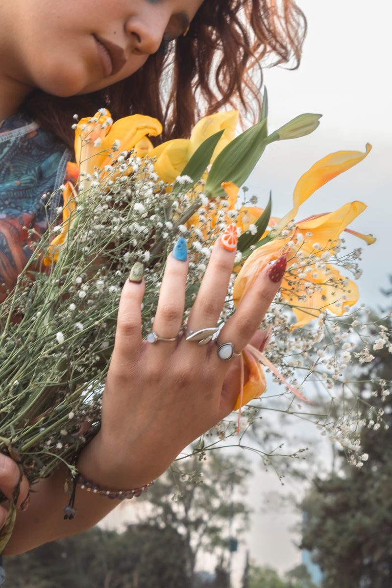 Opalite jewelry, worn with even a small degree of conscious intention, can be one of those practices. Not because the stone has mystical properties, but because its visual depth and gentle presence create exactly the conditions for the kind of quiet, repeatable awareness that genuine mindfulness is built from. Close-up of a woman holding a colorful bouquet with yellow lilies and wildflowers.