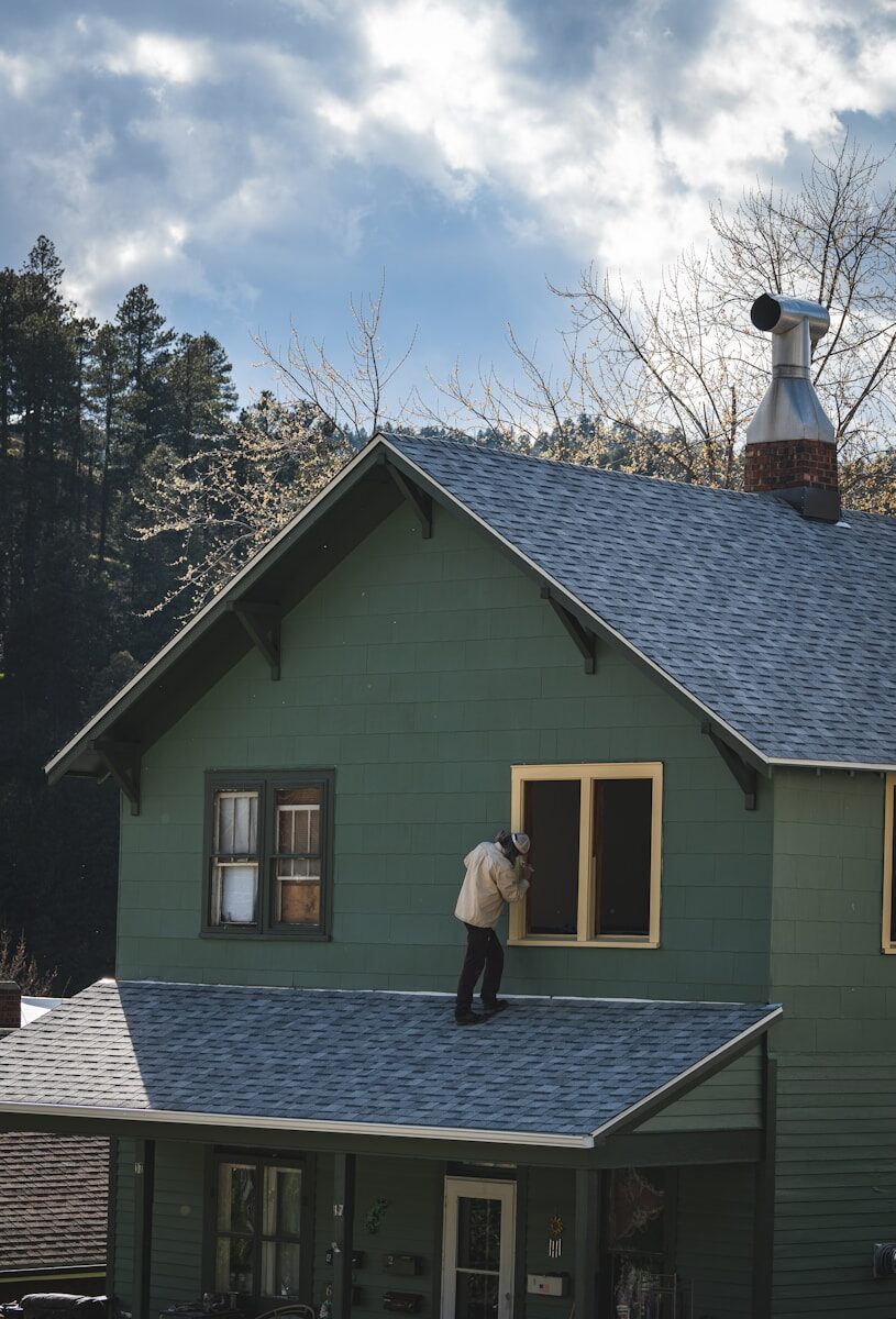 How to Sell Your House Fast in Orange Park, FL: A Complete Guide for Homeowners Person on roof painting a house window