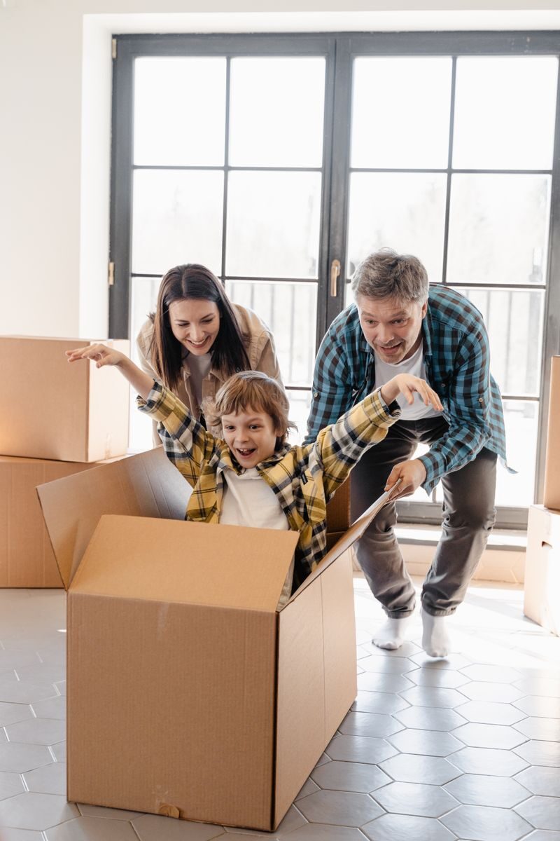The Ultimate Moving Across the Country Checklist in 2026 Happy family playing with boxes while moving into a new home, full of joy and excitement.