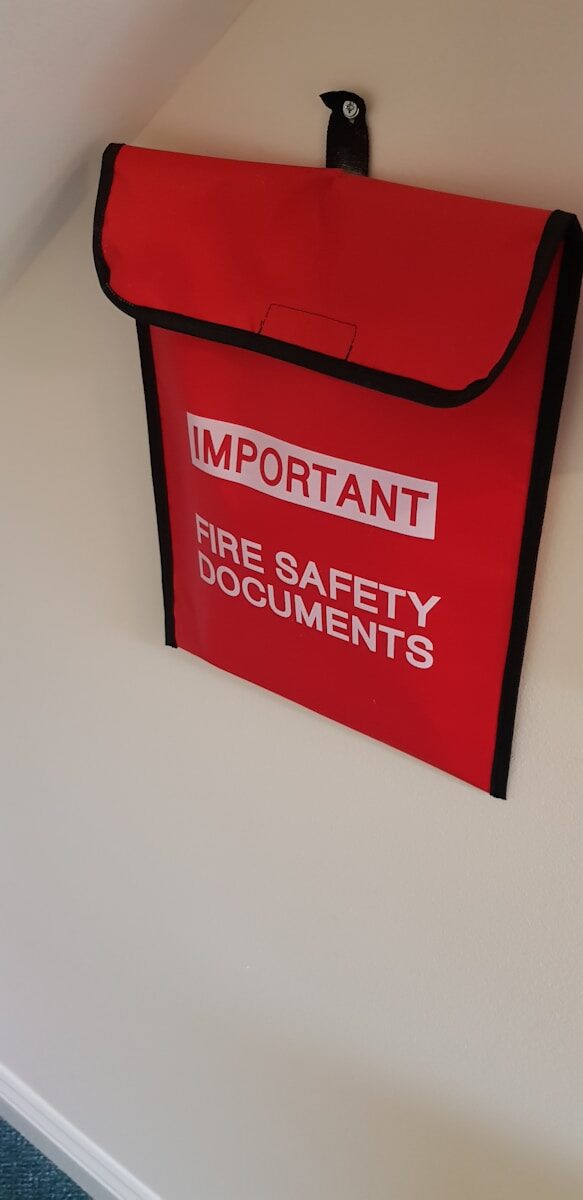Staying Compliant: Navigating Fire and Life Safety Regulations in 2026 a red fire safety bag hanging on a wall