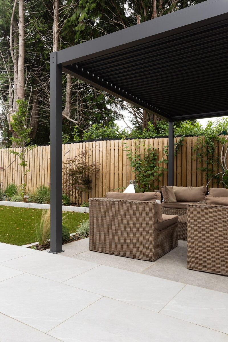 The Benefits of Outdoor Shades for Residential and Commercial Properties a covered patio with a couch and chairs