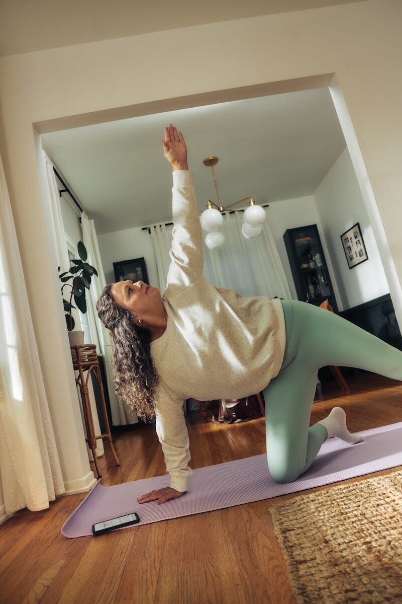 Exercise and yoga- healthy living tips A woman does a yoga pose on a mat.