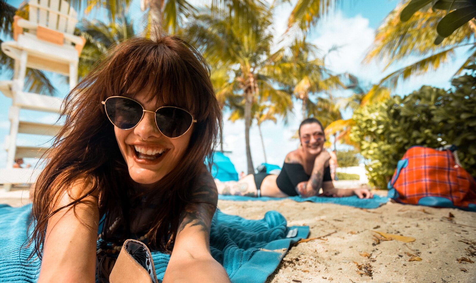 Best Practices for Choosing a Luxury Vacation Rental in Turks and Caicos a woman laying on top of a blue towel on top of a beach