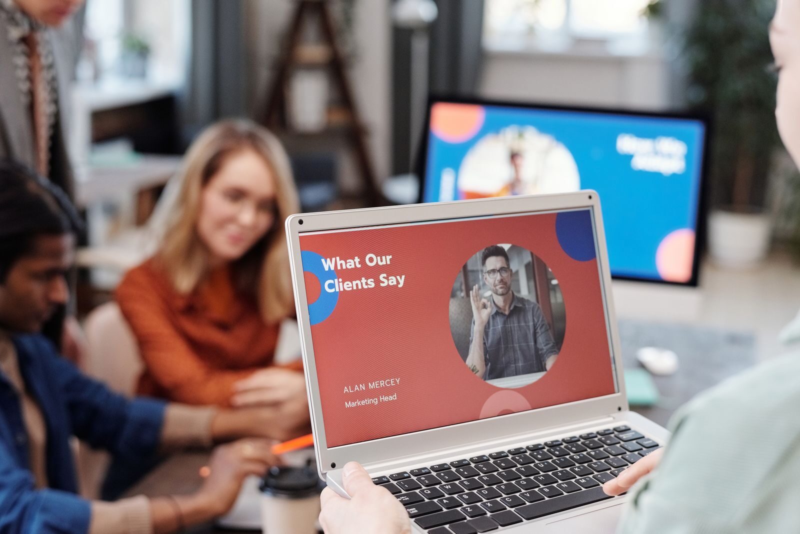 How to Create a High-Converting Marketing Website: A Practical Guide Diverse business team in a meeting analyzing client testimonial on laptop screen.