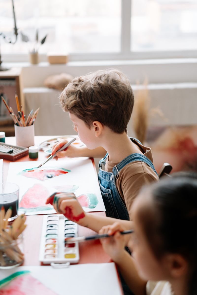 7 Things Parents Should Look for When Choosing an After-School Program Children painting with watercolors in a sunny, indoor art workshop.