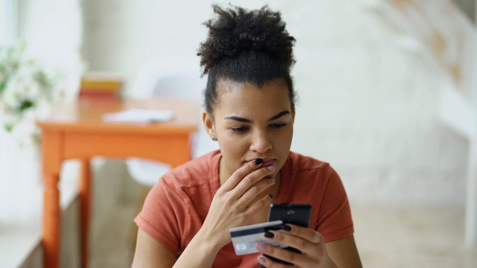 5 Steps to Get Over Your Fear of Credit Woman looking at phone with credit card in hand