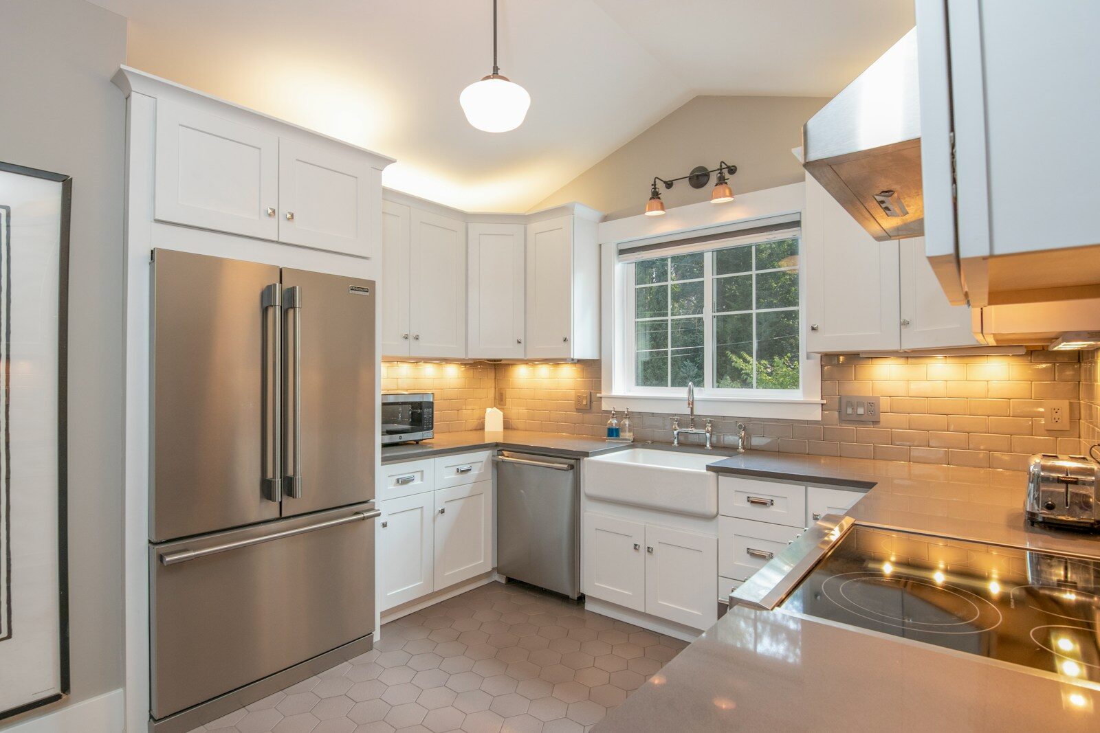 A Practical Guide to Kitchen Lighting and Cabinet Hardware white wooden kitchen cabinet and white pendant lamp