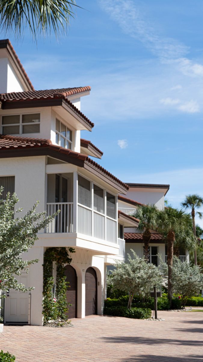 How To Compare Luxury Home Communities Without Overlooking The Real Costs Beautiful beachfront home in Florida City with lush palm trees and clear skies.