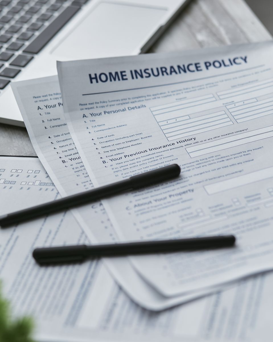 A Practical 2026 Insurance Checkup for Colorado Homes, Cars, and Small Businesses Close-up of home insurance documents with a laptop for financial planning.