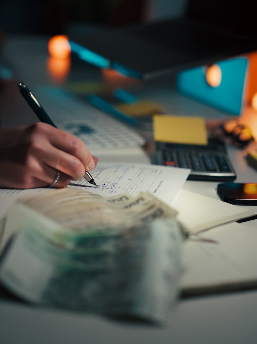 How to Choose the Right Business Loan for a One-Time Project Hand writing in notebook with calculator and cash