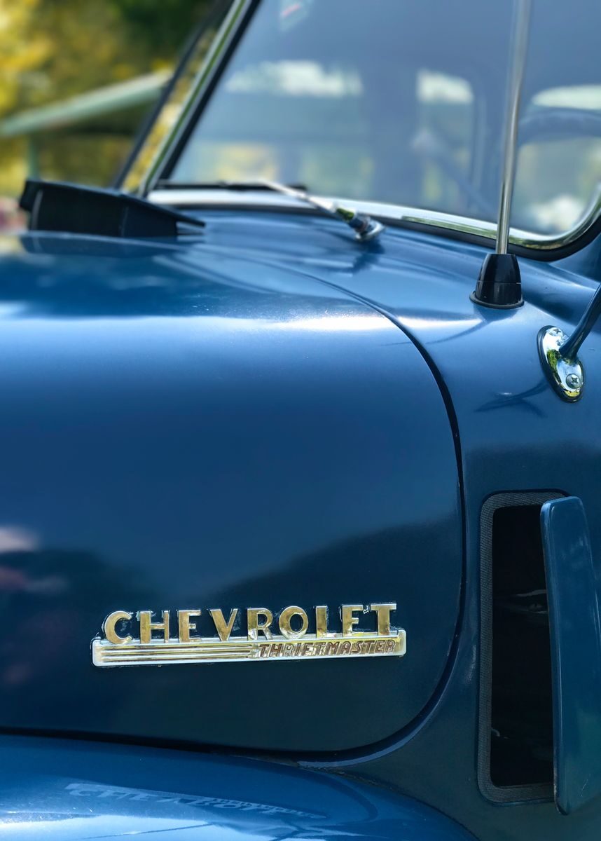 Yoba Falcon: An Automotive Enthusiast’s Take on What Keeps Chevy Trucks a Favorite Among Drivers Detailed view of a classic Chevrolet truck hood with emblem and glossy blue paint.