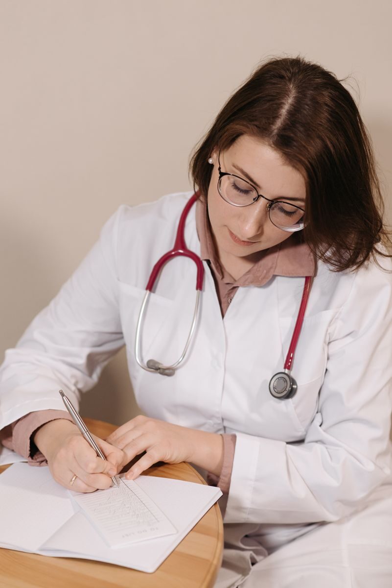 Questions to Ask About Integrated Treatment in Ohio Female doctor writing a prescription in a clinical setting. Professional medical attire with stethoscope.