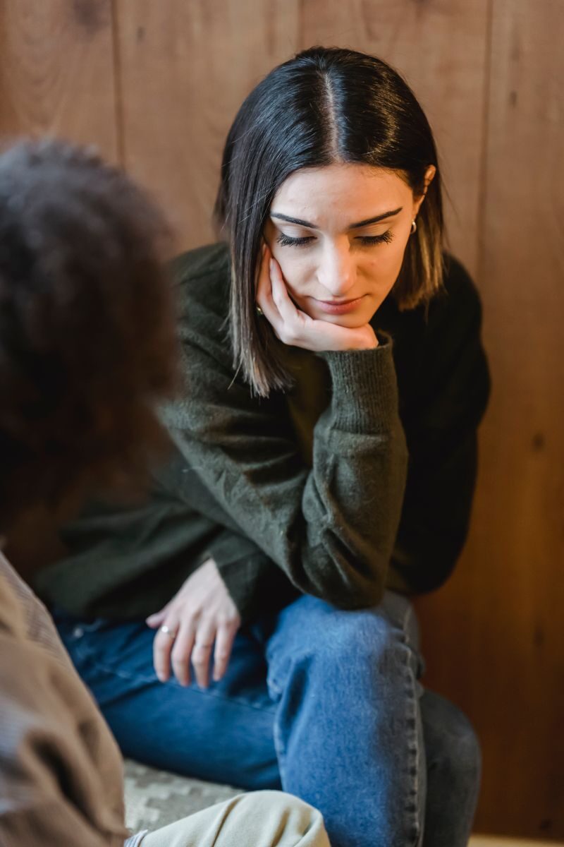 Questions to Ask About Integrated Treatment in Ohio High angle of disappointed young female leaning on hand while sitting with crossed legs near crop girlfriend