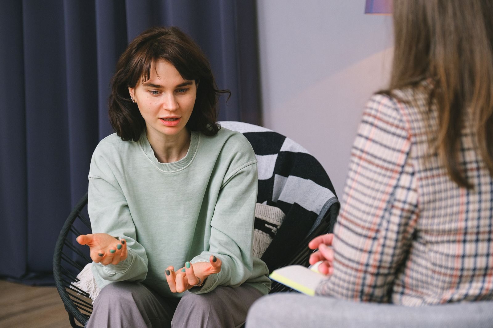 7 Best New Jersey Rehab Centers for Personalized Addiction Care (2026) Calm female sitting on armchair and giving interview to concentrated woman in light room