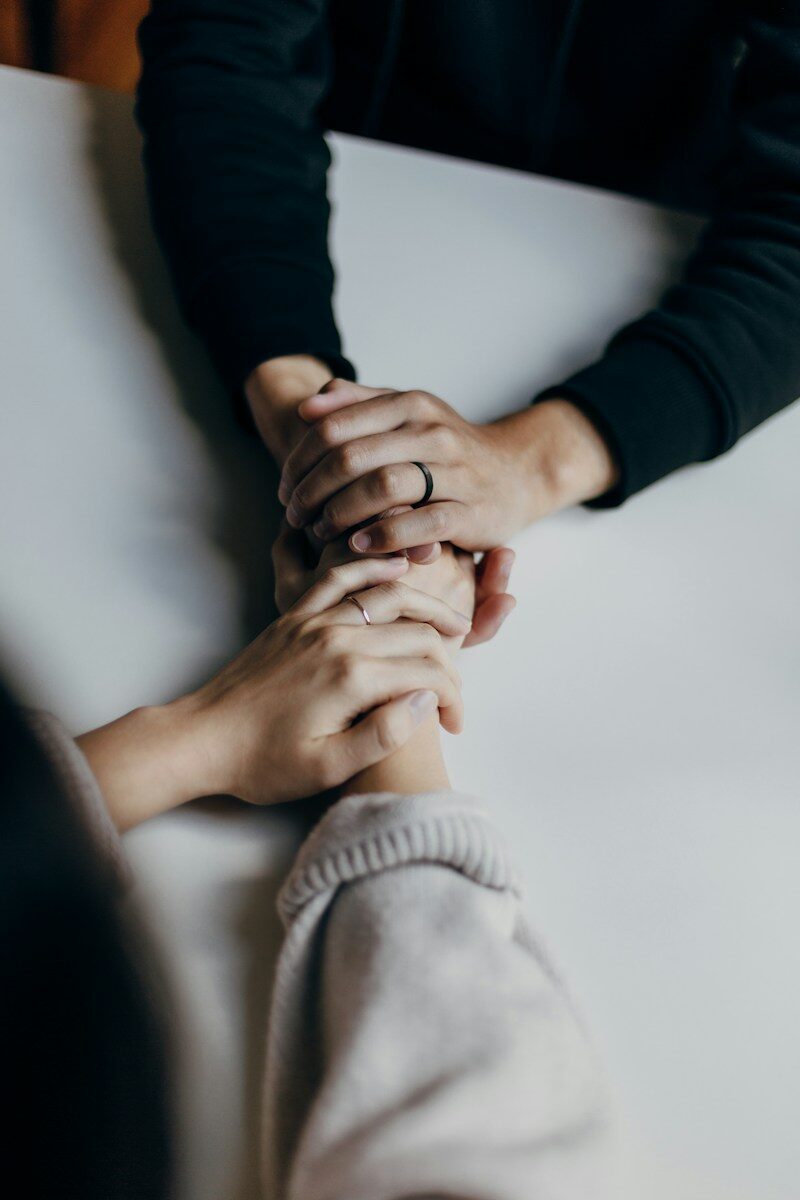 7 Best New Jersey Rehab Centers for Personalized Addiction Care (2026) wo people holding hands on table in comfort