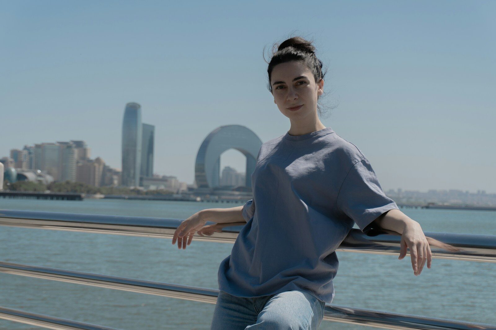 Working From Home While Prioritizing Mental Health: A Practical Recovery Guide A woman poses by the water with city skyline