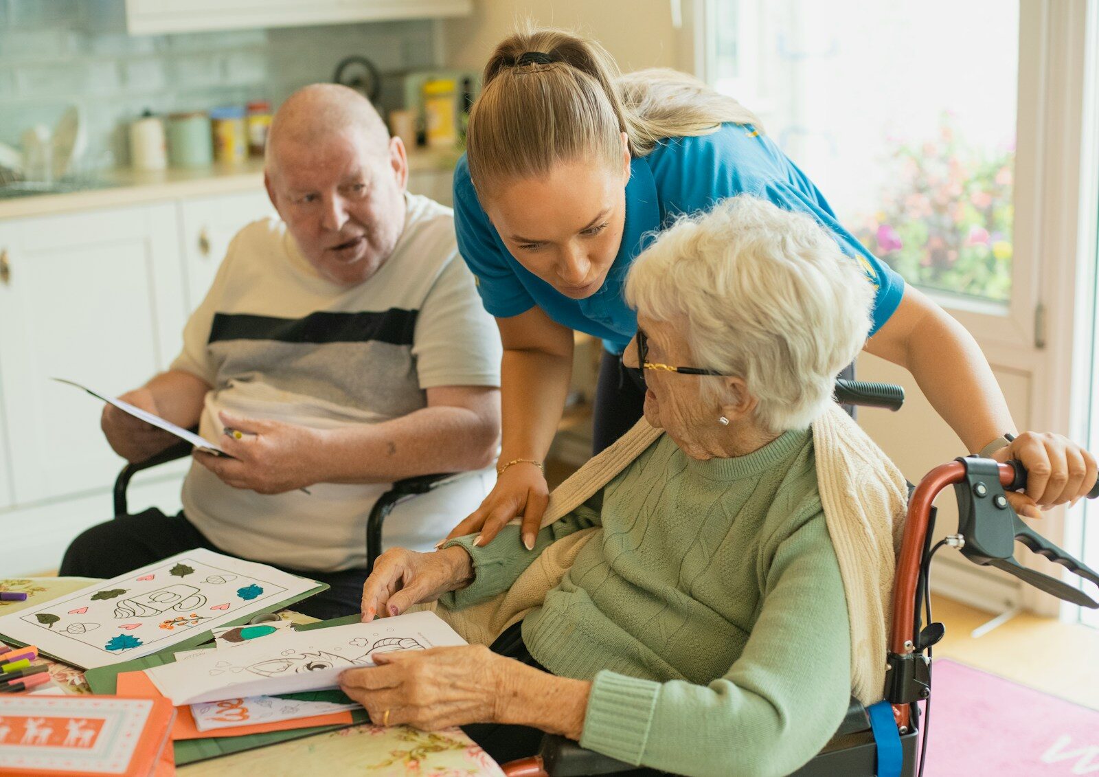 7 Best In-Home Care Services for Seniors in Dallas - Fort Worth (2026) Caregiver assisting elderly couple with coloring