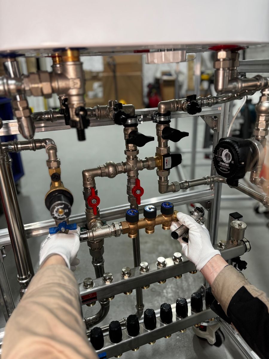 Backflow Prevention for Businesses: Annual Compliance Guide for Commercial Property Managers Engineer adjusting metal pipeline valves in an industrial setting with precision.