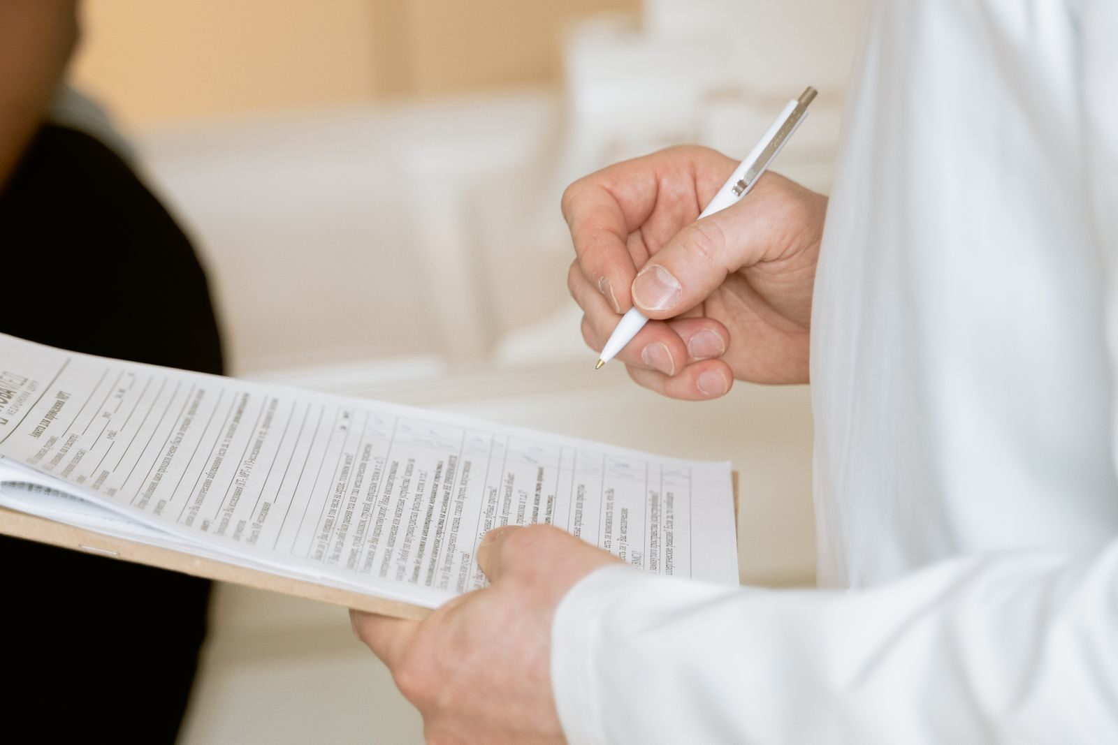 Why Medical Documentation Matters for Health and Social Security Disability A medical professional in a white coat examines a clipboard with patient documents.