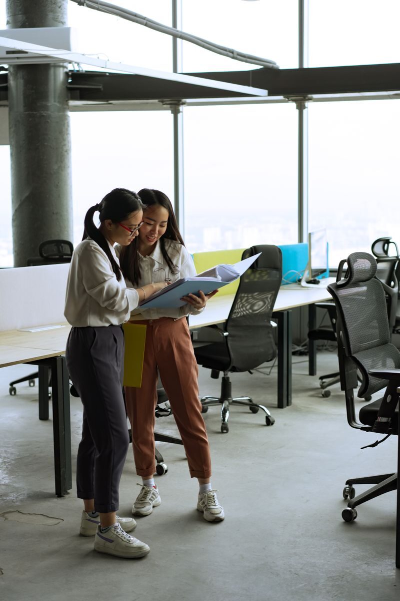 How Electrical Floor Boxes Support Technology-Heavy Commercial Spaces Two women reviewing documents in a spacious, well-lit modern office setting.