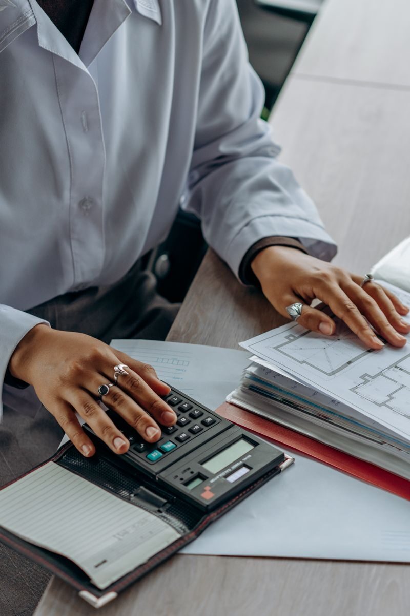 How to Manage Cross-Border Tax and Accounting Accountant calculates finances with a calculator and documents on a desk.