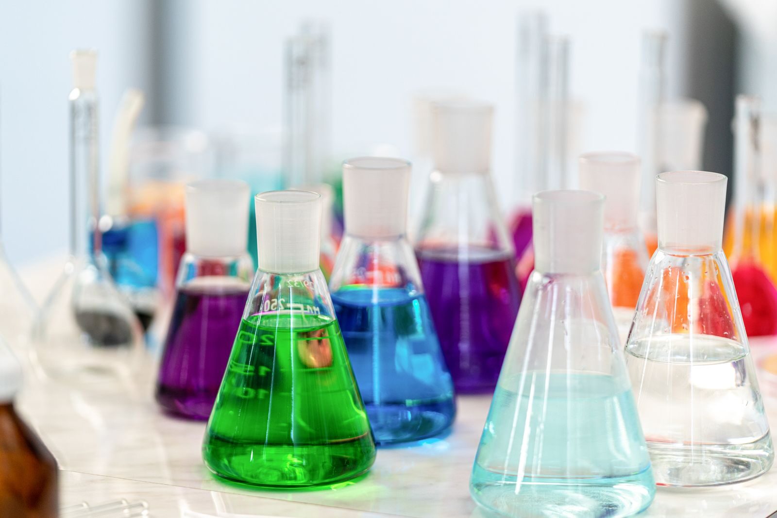8 Best Research Peptide Suppliers for BPC-157 and Laboratory Compounds Close-up of colorful chemical solutions in glass beakers in a laboratory setting.