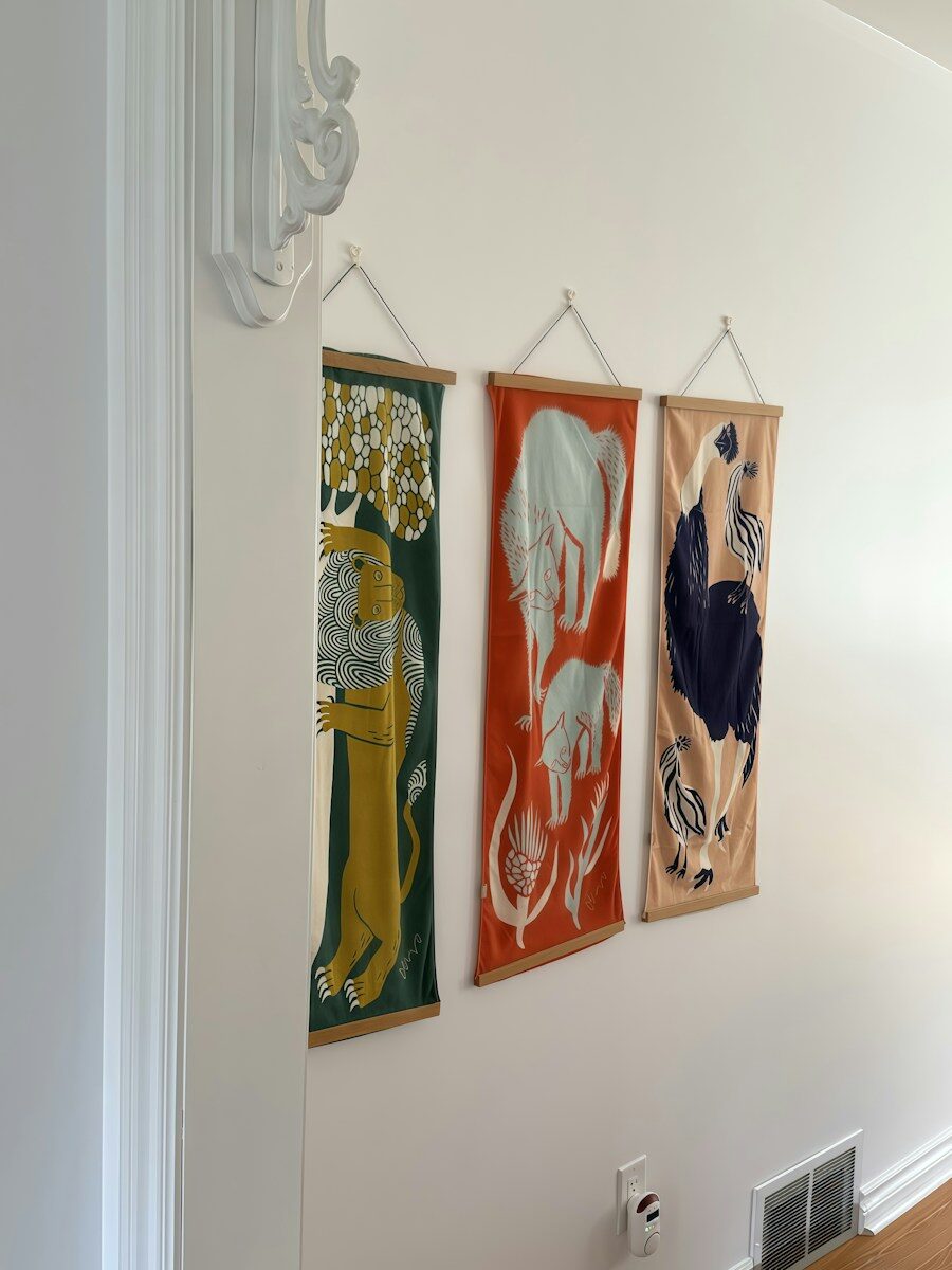 Animal art in cozy interior design Three animal tapestries hanging on a white wall