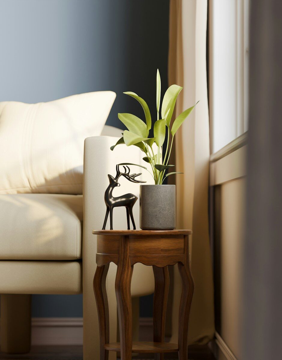 Animal art in cozy interior design A small potted plant and a black deer figurine on a wooden side table